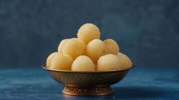 AI generated The rasgullas kept in a shallow bowl, dipped in sugar syrup.  Luxuious indian background. Plain deep navy blue background. Generated by artificial intelligence. photo