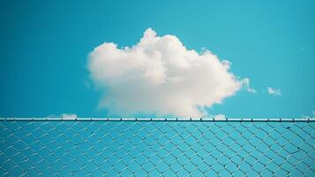 Clouds in the blue sky behind an open chain link fence. photo