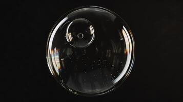 A sphere made of glass, clear and transparent, front view, black background, glass bubble. Generated by artificial intelligence. photo