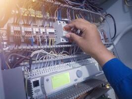 The electrician turn off the circuit breaker on the panel control machine. Electrician check and service concept. photo