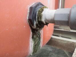 el toma de corriente tubo línea en el agua reservorio es cubierto de musgo debido a un agua filtración. foto