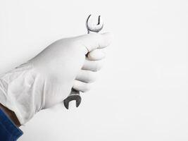 Man's hand with gloves holds a wrench tools isolated on white background. photo