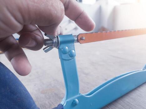 Checking sharpness and showing the correct direction of the hacksaw teeth. photo