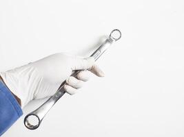 Man's hand with gloves holds a spanners isolated on white background. Mechanical tools concept. photo