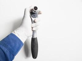 Man's hand with gloves holds a Ratchet Wrench isolated on white background, Mechanical tools wrench concept. photo