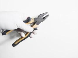 Man's hand holds a pliers yellow and black color isolated on white background. photo