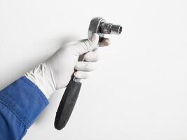 del hombre mano con guantes sostiene un trinquete llave inglesa aislado en blanco fondo, mecánico herramientas llave inglesa concepto. foto