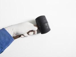 Man's hand with gloves holds a rubber hammer isolated on white background.Carpenter tools concept. photo