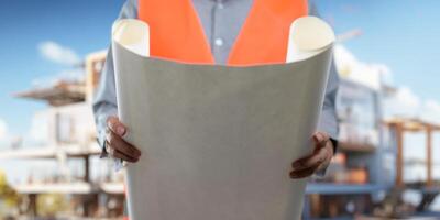 Engineer holding construction blueprint template for building, house, checking accuracy. photo