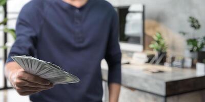 Businessman holding banknotes, investing in stocks, buying and selling goods, income, expenses, saving money, bank deposits, borrowing money. photo