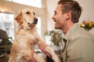 Close up portrait of cute dog and happy man, guy hugging his pet, spending time in animal-friendly cafe, waiting for an order photo