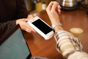 hombre en café pago sin contacto utilizando su digital reloj en muñeca, participación eso cerca a el pos sin contacto Terminal, trabajando desde trabajo colaborativo foto