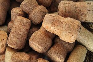 Pile of natural wooden wine corks close up as background. Concept of environmental protection and waste separation. Recycled closures used for sealing wine bottles photo