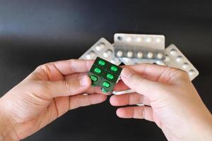 Green pill in man's hand. photo