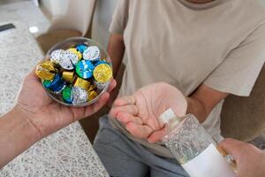 Young man pouring cologne to an elder man with a bowl of candy or chocolate. Eid al fitr in Turkey background . Traditional Eid al Fitr candies. photo