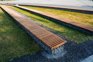 calle paisaje de el ciudad parque, de madera bancos hecho de tableros, césped para relajante en el sombra de árboles, caminando parque en el Fresco aire, moderno diseño foto