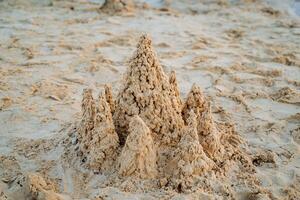 descanso en el mar construye torretas de arena, un arena castillo, blanco multa arena. foto