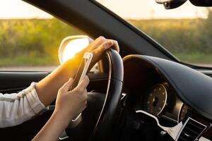 mujerconductor utilizando móvil teléfono pago para estacionamiento y navegando en el ciudad mientras detenido en el lado de el la carretera. yo la carretera viaje, tecnología, viaje y personas concepto foto