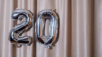 20 veinte metálico globo aislado en altas textil antecedentes. saludo tarjeta plata frustrar globo número contento cumpleaños fiesta concepto. Copiar espacio para texto. celebracion fiesta felicidades decoración foto