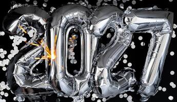 Happy new year 2027 metallic balloons with confetti and sparkler firework Bengal lights on dark black background. Greeting card silver foil balloons numbers Christmas holiday concept. Celebration party congratulation decoration photo