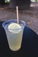 un enfriado vaso de limonada coronado con un limón rebanada foto