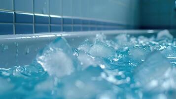 Tub filled with ice and water beside tiled wall, close up photo