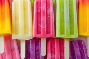 Group of colorful popsicles on ice, closeup photo