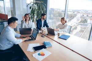 Creative business people working on project in modern office with panoramic view photo