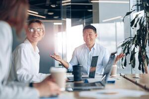 Positive workteam of young asian businessman working together in an modern office photo