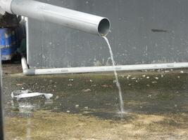 Photo of rainwater from pipes and floors on the top floor of an urban building