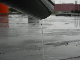 Photo of rainwater from pipes and floors on the top floor of an urban building