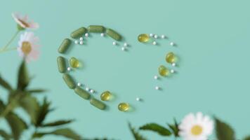 herbario y homeopático suplementos ingeniosamente arreglado en un corazón forma en un pastel verde fondo, Perfecto para temas de natural salud. Respetuoso del medio ambiente, alternativa medicamento. Copiar espacio. 3d animación. video