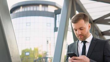 een moe zakenman gebruik makend van een mobiel telefoon Bij de einde van de werken dag. sociaal netwerk. mensen video