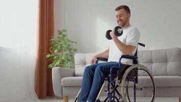 Disabled athlete in wheelchair performs exercises with dumbbells, home training and physical activity. Disability concept video