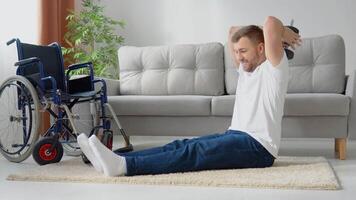 Disabled athlete performs exercises with dumbbells on wheelchair background. Home training and physical activity video