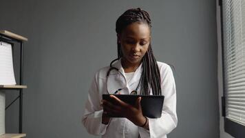 Young african woman doctor works with a tablet video