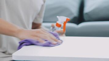 Woman cleaning table using rag and diffuser at home. video