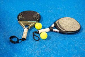 rackets paddle with two balls on blue background photo