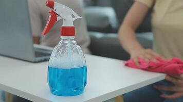 Woman cleaning table using rag and diffuser at home. video