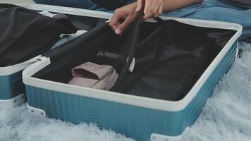 asiatisk kvinna förbereda till packa kläder resa platser med henne vänner. asiatisk skön två kvinnor vän packa saker i din resa väska för högtider för henne semester resa video