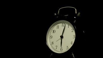 The alarm clock on a black background, in the style of time-lapse . video