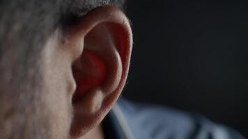 Close up of young man ear with a yellow background. video