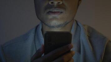 Cerca de la mano del hombre con teléfonos inteligentes por la noche video
