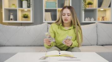 le Jeune femme qui jette argent dans le porcin banque. Accueil économie et des économies. video