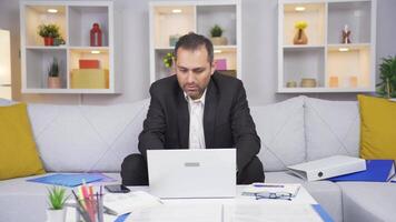 Home office worker man working on laptop stressed. video
