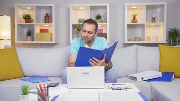 Home office worker man looking at paperwork files. video