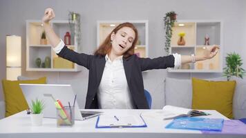 Home office worker woman yawns and relaxes at the camera. video