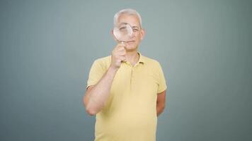 Man looking at camera with magnifying glass. video