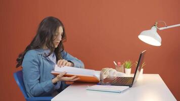 Young woman working on laptop throws files angrily. video