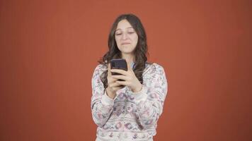 Happy young woman texting on the phone. Smiling. video